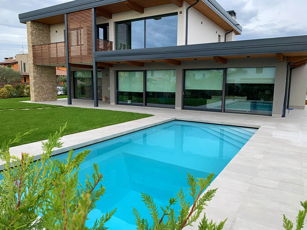 Realizzazione piscina esterna a sfioro per villa moderna - Piscine Interrate Moderne - Baires Piscine